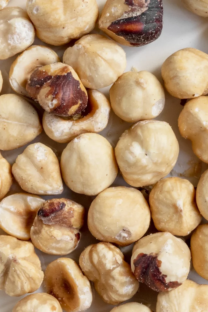 Roasted hazelnuts on a white plate.