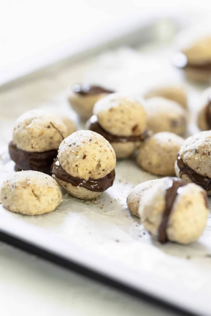 Chocolate covered macarons on a baking sheet.
