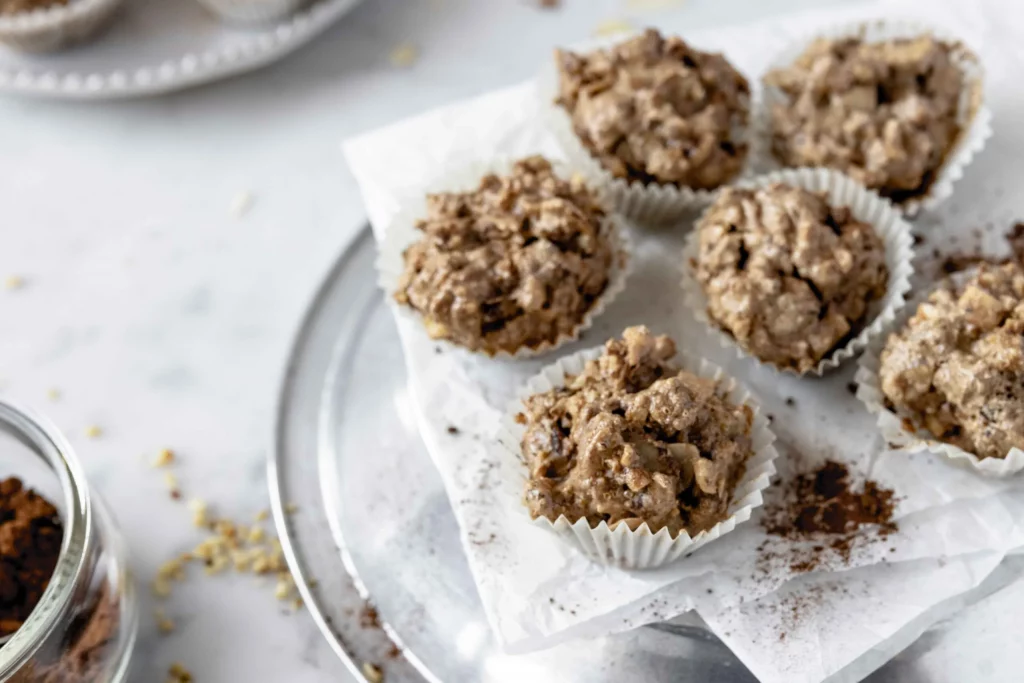 Chocolate oatmeal muffins on a plate with a cup of coffee.