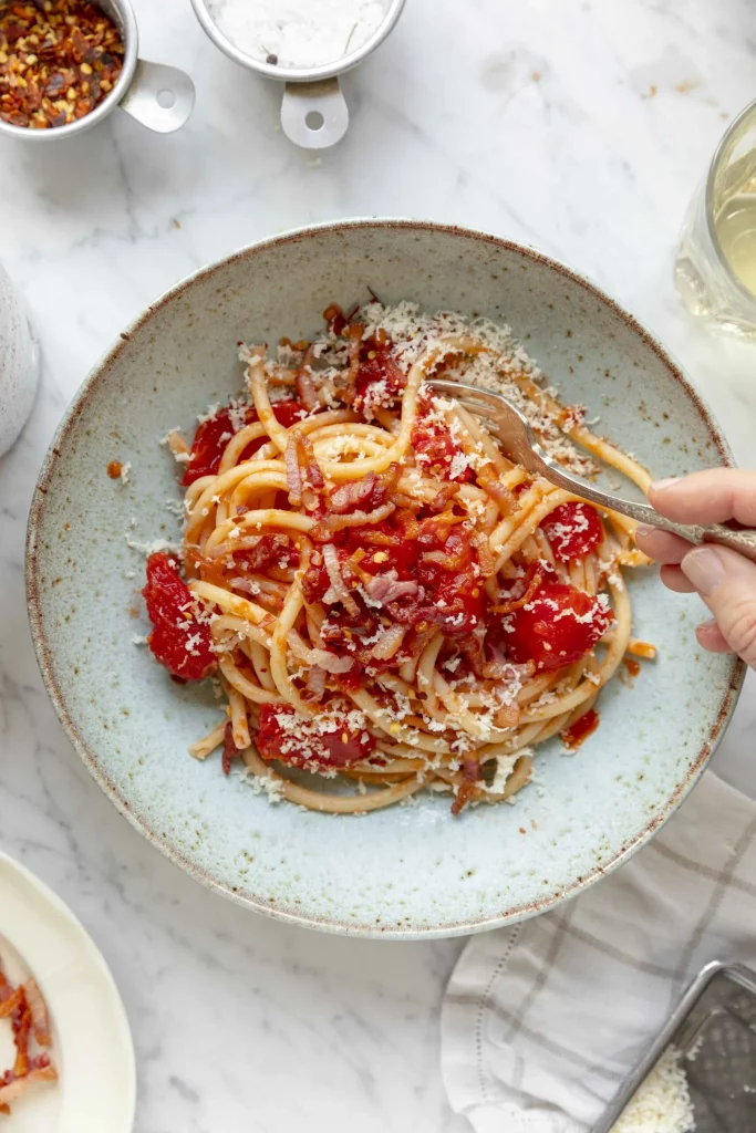 A plate of spaghetti with tomatoes and parmesan.