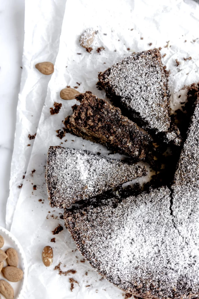A chocolate cake with almonds and powdered sugar.