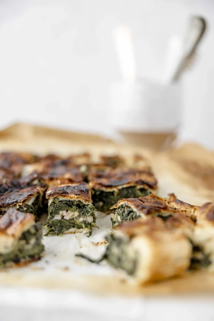 A slice of spinach pie on a baking sheet.
