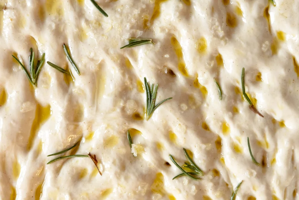 A close up of a dish with rosemary sprigs on it.
