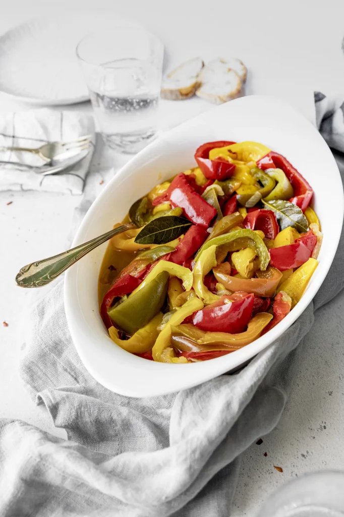 A white bowl filled with peppers on a table.