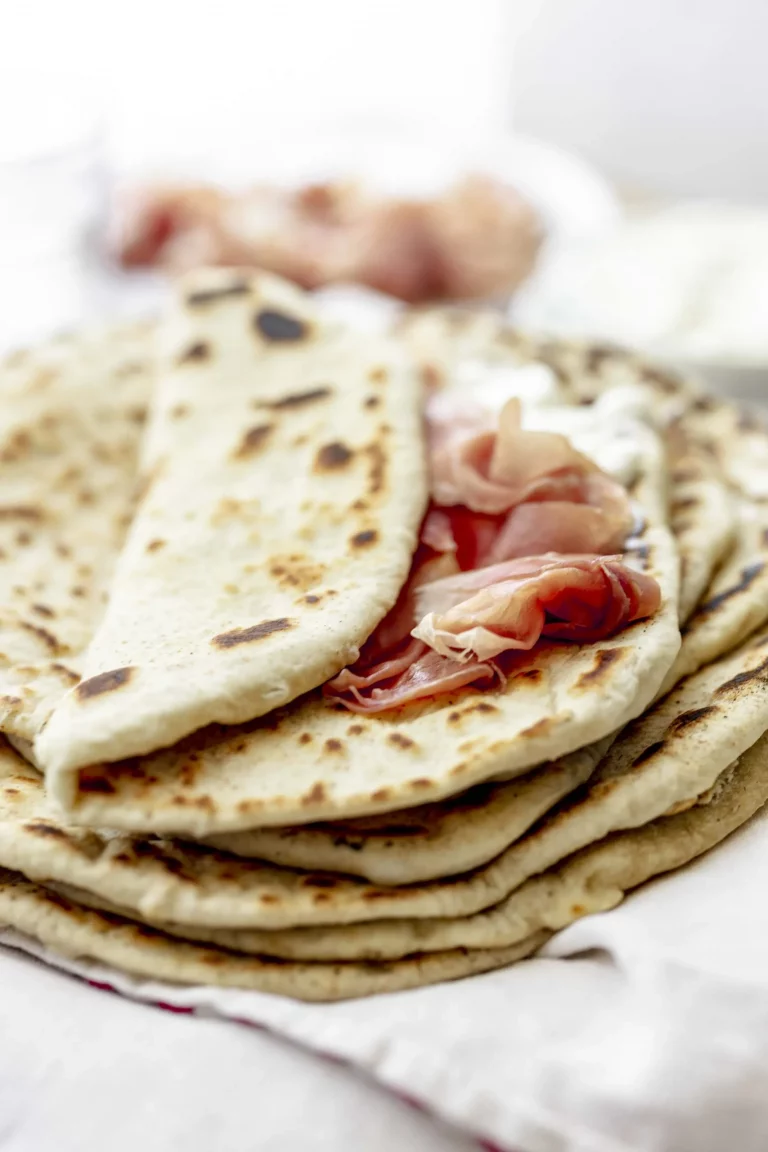 A stack of pita bread with ham and cheese.