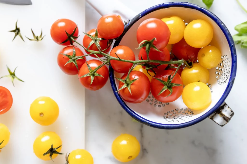 Tomatoes in a bowl on a cutting board.