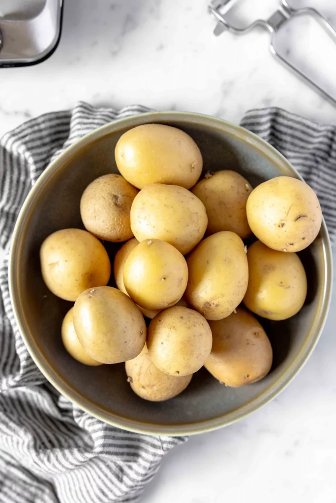 Potatoes in a bowl on top of a towel.