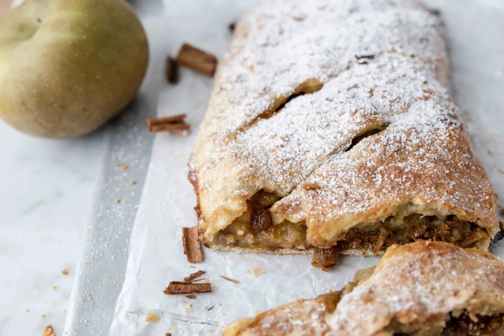 A pastry with apples and powdered sugar.