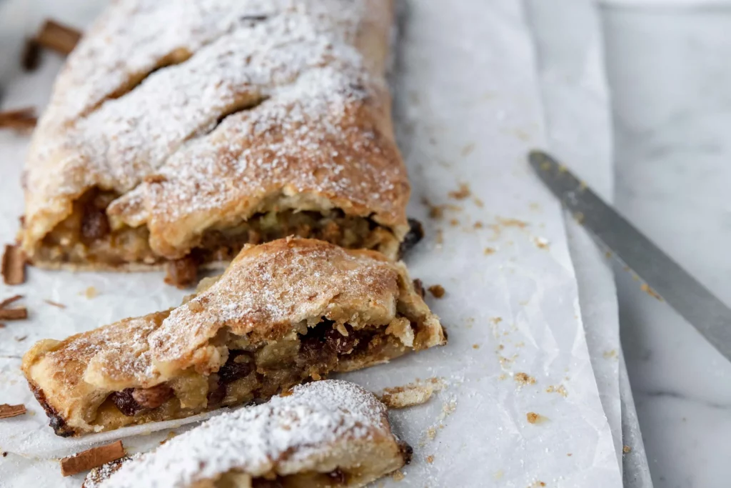 A pastry with powdered sugar and pecans on top.
