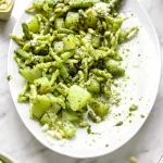 A plate of trofie with pesto and pine nuts.
