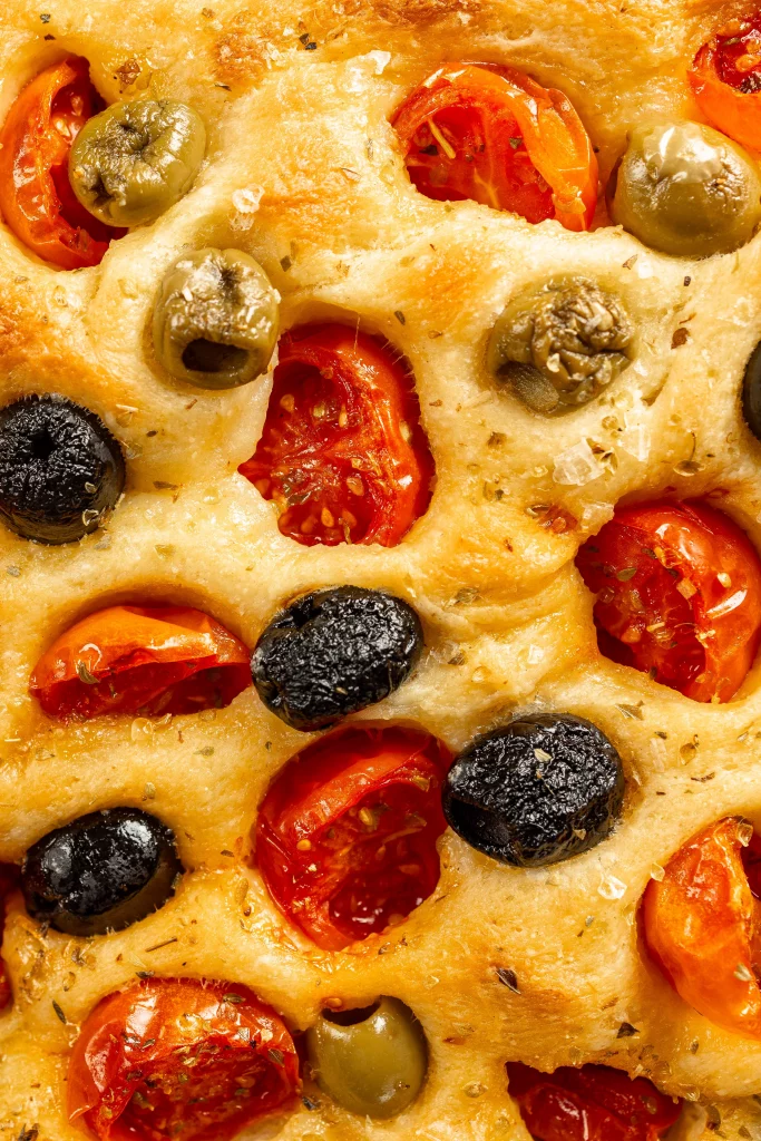 Close up of apulian flatbreadwith olives and cherry tomatoes.